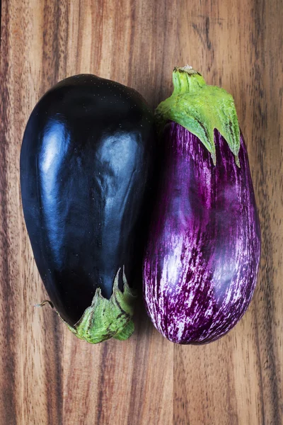 Ruwe aubergines over hout achtergrond — Stockfoto