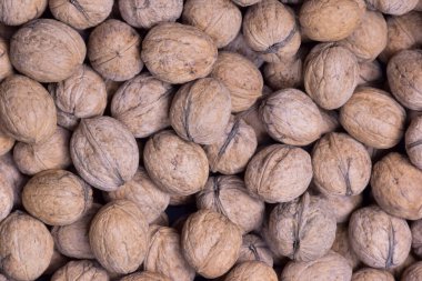 Kabuklu cevizlerin çoğu, kabuğu soyulmamış, yakın plan çerçeveye saçılmış.