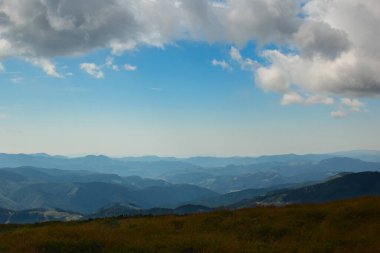 Dağların yamacı ve dağların uzaklığı gökyüzüne karşı bulutların sisi içinde.