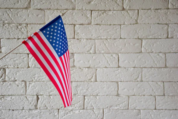 On the left side of the frame is the USA flag on a light brick wall background. On the right is an empty space to insert text