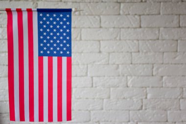 Çerçevenin sol tarafında Amerikan bayrağı var. Bu bayrak, bir BLURED duvarının arka planında. Sağ tarafta metin eklemek için boş bir alan var. Bulanık arkaplan
