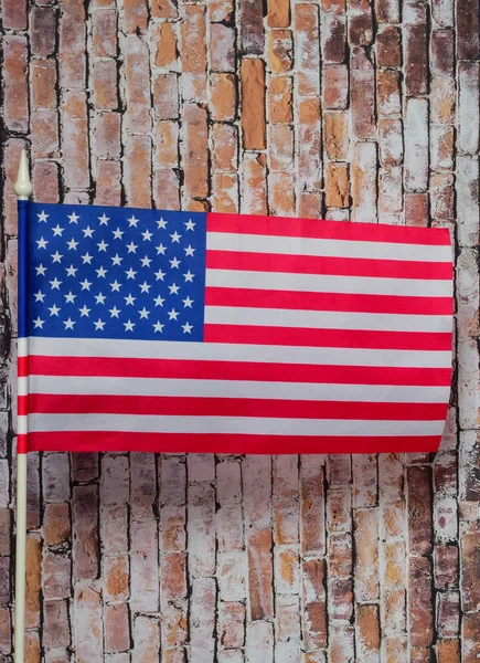 旧砖墙背景上白旗杆上的美国国旗 — 图库照片