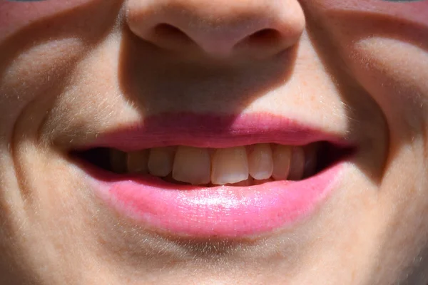 Boca feminina sorridente e parte do rosto pintada com batom rosa ou brilho labial — Fotografia de Stock