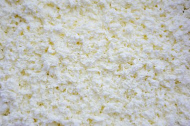 Beyaz kırıntılı süzme peynir tüm çerçeveye yakın plan çekilmiş.