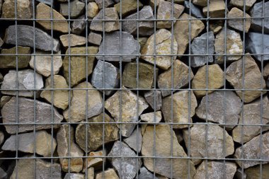A large fence of many stone cobblestones supported by a stone trellis for the entire frame. The design takes up the entire background