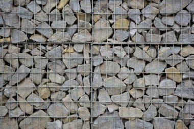 A large fence of many stone cobblestones supported by a stone trellis for the entire frame. The design takes up the entire background
