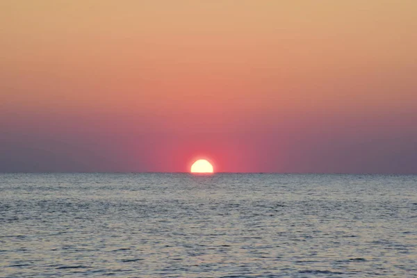 El sol de la mañana medio subió del mar tranquilo. —  Fotos de Stock