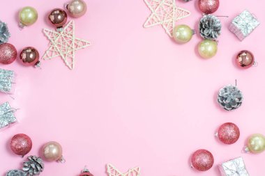 Noel kompozisyonu. Pastel pembe arka planda Noel süslemeleri. Toplar, külahlar, yıldızlar. 2021 yılı. Düz dizme, üst görünüm, kopyalama alanı.