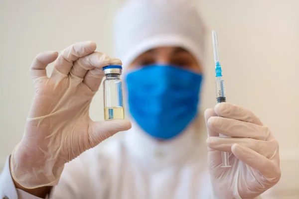 Covid-19 Corona virüsüyle mücadele konsepti, bir kız doktor içinde çocuklar ve yaşlılar için sıvı aşılar bulunan bir şırınga taşıyor..