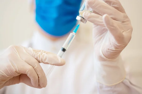 Covid-19 Corona virüsüyle mücadele konsepti, bir kız doktor içinde çocuklar ve yaşlılar için sıvı aşılar bulunan bir şırınga taşıyor..
