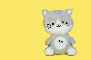 Komik oyuncak kedi, gri renkli, sarı arka planda. Çocuklar için eğitici oyuncaklar.