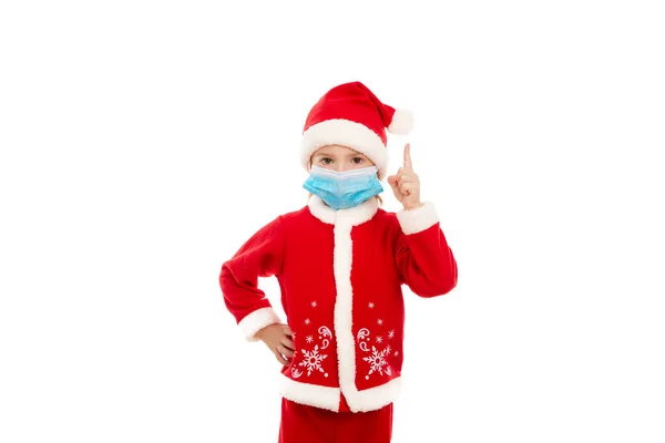 Liten Pojke Röd Jultomte Står Vit Bakgrund Blå Medicinsk Mask — Stockfoto