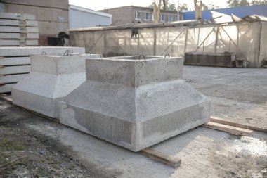 Sanayi binaları ve atölyelerin yapımında kullanılan yük taşıyan sütunlar için güçlendirilmiş beton temeller. Vakıflar, önceden hazırlanmış beton fabrikasının deposunda satılmaya hazır.