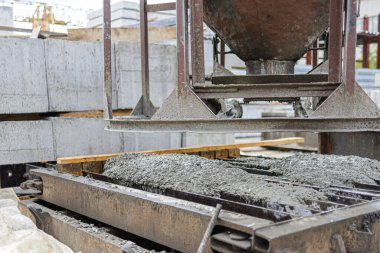 Güçlendirilmiş beton levhaların, önceden ısıtılmış metal kalıpların betonla dökülmesinin fotoğrafı..