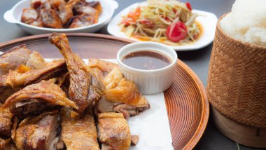 Kızarmış ördek, tuz, çıtır çıtır deri. Kızarmış yemek gibi çıtır çıtır bir ördek. Papaya Salatası 'yla yediği için ızgara ya da fırında tavuk, yapışkan pirinç, Tayland' ın kuzeydoğusunda popüler bir öğle yemeği..