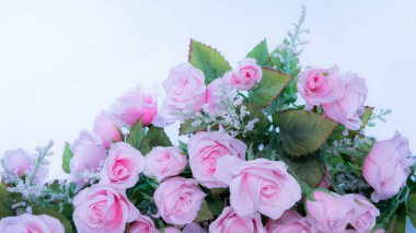 Sevgililer Günü konseptinde çerçeve ve arkaplan yapmak için beyaz bir yüzeye koyulmuş pembe gül buketi. Kumaş ve plastikten yapılmış sahte bir buket..