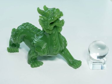 Pixiu ya da Pi Yao yeşimden yapılmış. İbadet için uğurlu bir oyuncak ve ticarette iyi talih, zenginlik ve refah için bir nimet. Çin inançlarına göre beyaz bir arkaplanda.