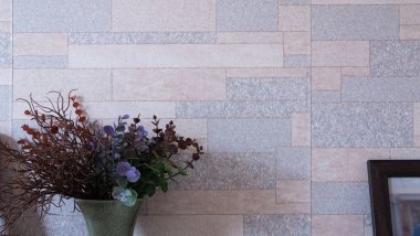 Sahte bitkiler ve saksılardaki çiçekler açık mavi ve mor karışımlı mermer duvarın önüne konur. Duvar deseni, duvar kağıdı veya arkaplan bir ızgaradır.