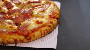 Sosis ve Jambonlu Peynirli Pizza. Teslimat kutusundaki pizza mermer masanın üstünde teslim edildi..
