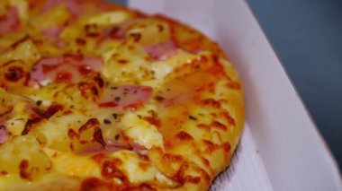 Sosis ve Jambonlu Peynirli Pizza. Teslimat kutusundaki pizza mermer masanın üstünde teslim edildi..