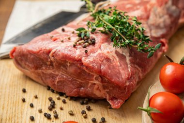 Tahtada baharat ve otlarla dilimlenmiş çiğ et parçaları. 