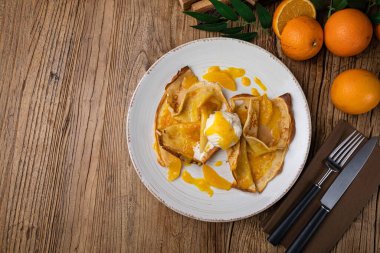 Portakal reçelli krep ve büyük beyaz tabakta dondurma.