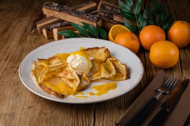 Portakal reçelli krep ve büyük beyaz tabakta dondurma.