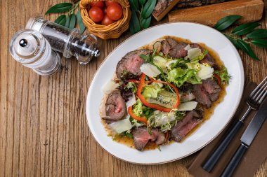 Dana eti, bitki, biber, salatalık ve parmesanlı salata.