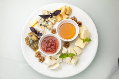 Beyaz tabakta roka, domates, marul ve mozzarella peynirli salata..