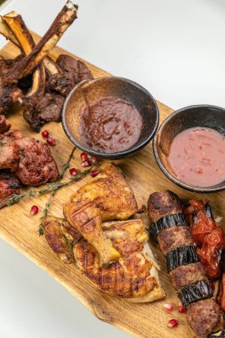 Ahşap masada sos ve baharatlı ızgara domuz kaburgası.