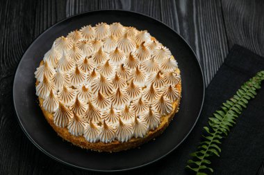 Koyu ahşap masada limonlu pasta.