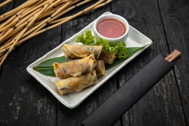 Sebzeli Vietnam dürümü, pirinç eriştesi ve ahşap yüzeyde tatlı acı biber soslu karides.