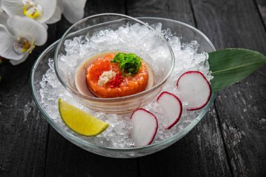 Somon tartar ve havyar. Buzun üzerinde, karanlık bir masanın üzerinde.