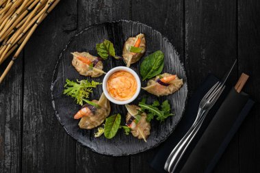 Japon restoranındaki karanlık bir masada Japon mantısı.