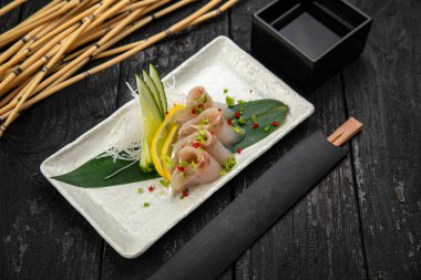 Karanlık bir masada çeşit çeşit saşimi.