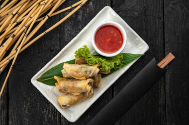 Sebzeli Vietnam dürümü, pirinç eriştesi ve ahşap yüzeyde tatlı acı biber soslu karides.