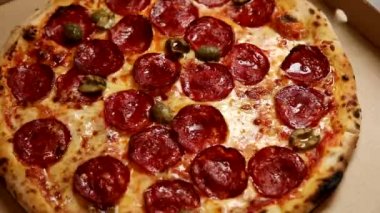 Şef sosisli ve peynirli pizza hazırlar. 