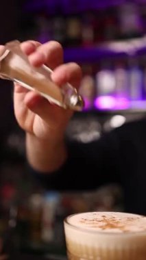 Barmen barın arkasında kokteyl yapar..