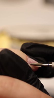 Bir manikürcü kuaförde manikür yapar..