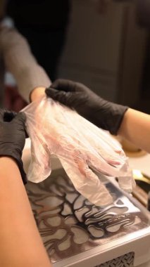 Bir manikürcü kuaförde manikür yapar..