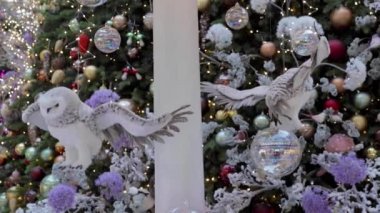 Oyuncak kutup baykuşları bir Noel ağacının arka planında uçar. Yeni yıl konsepti.