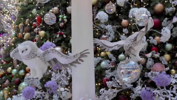 Toy polar owls fly against the backdrop of a Christmas tree. The concept of the new year. — Stock Video