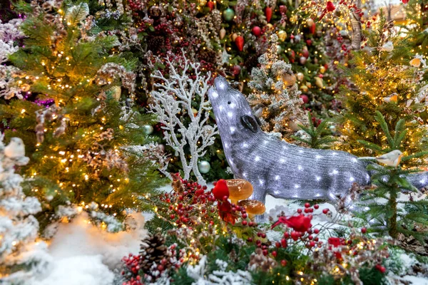 Un lobo brillante juguete se sienta debajo de un árbol de Navidad. El concepto del Año Nuevo. — Foto de Stock