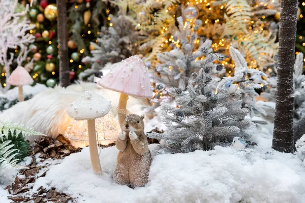 Oyuncak bir sincap, bir Noel ağacının arka planında karda oturur. Yeni yıl konsepti.