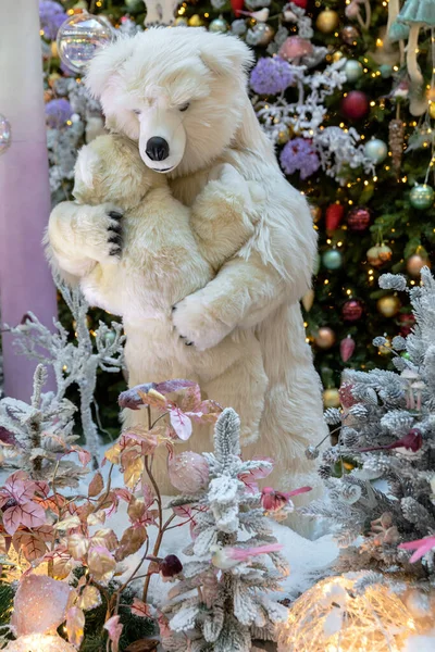 Bir kutup dişi ayısı Noel ağacının yanında bir ayı yavrusunu kollarında tutuyor. Dana Alışveriş Merkezi - Minsk Şehri, Belarus 8 Aralık 2020.