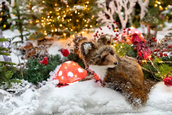 Oyuncak tilki bir peri ormanında oturur. Yeni yıl ve Noel konsepti.