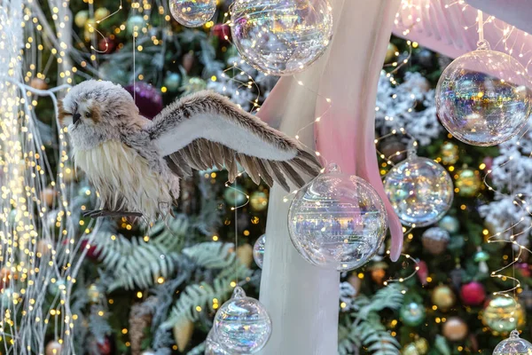 El búho de juguete vuela en el bosque de hadas contra el telón de fondo del árbol de Navidad. El concepto del Año Nuevo. — Foto de Stock