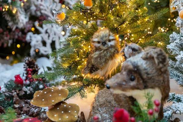 Oyuncak bir baykuş Noel ağacında oturur. Yeni yıl konsepti. Odak dışı arkaplan.