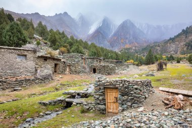Stone buildings in Karakorum mountains cloudy weather  clipart