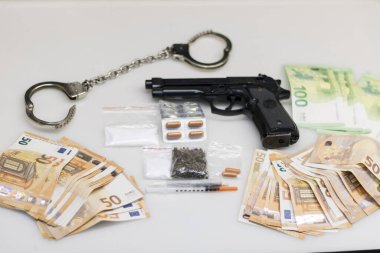 Polis tarafından ele geçirilen uyuşturucu sevkiyatı, kapsüllerde kaçak uyuşturucu, toz kokain, esrar veya kenevir ve satıştan elde edilen avroluk para.